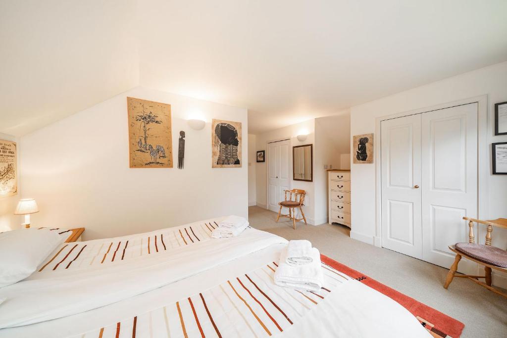 2 camas en un dormitorio con paredes blancas en Earnside Cottage, en Comrie