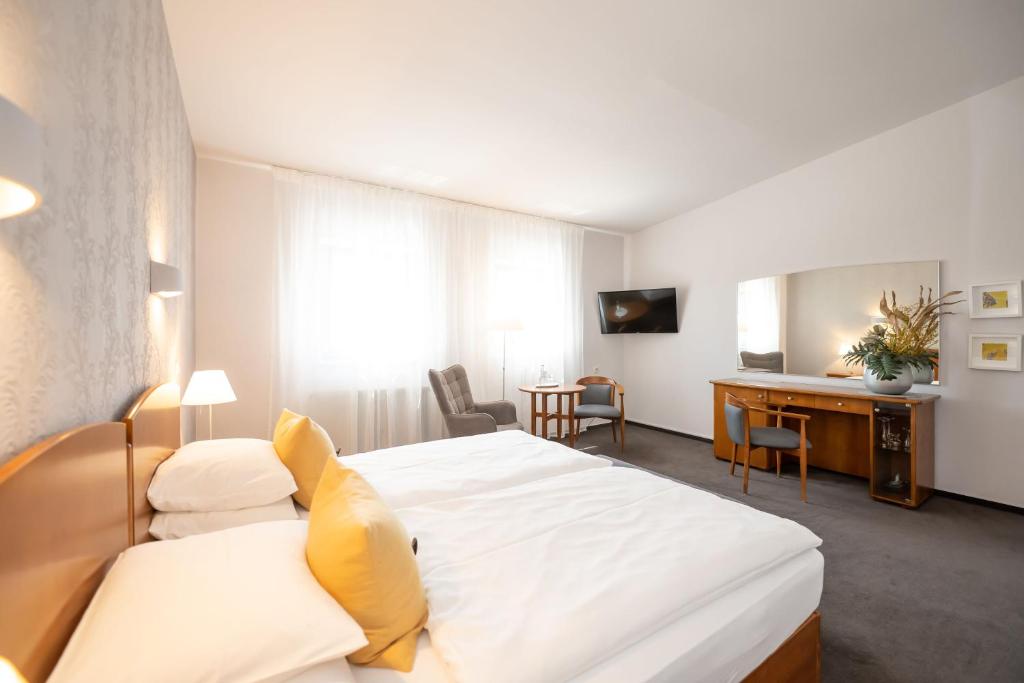 a hotel room with a bed and a desk at Hotel Moritz an der Elbe in Zeithain