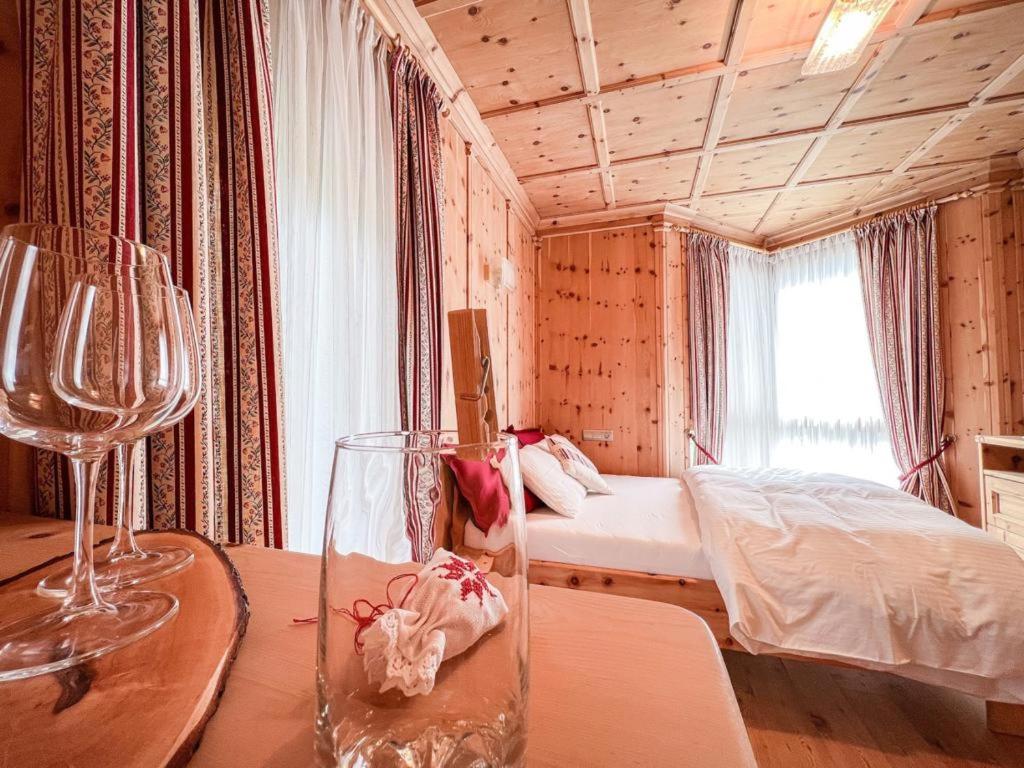 Habitación con cama y mesa con copas de vino en Fewo Zirbenglück, en Bad Kleinkirchheim