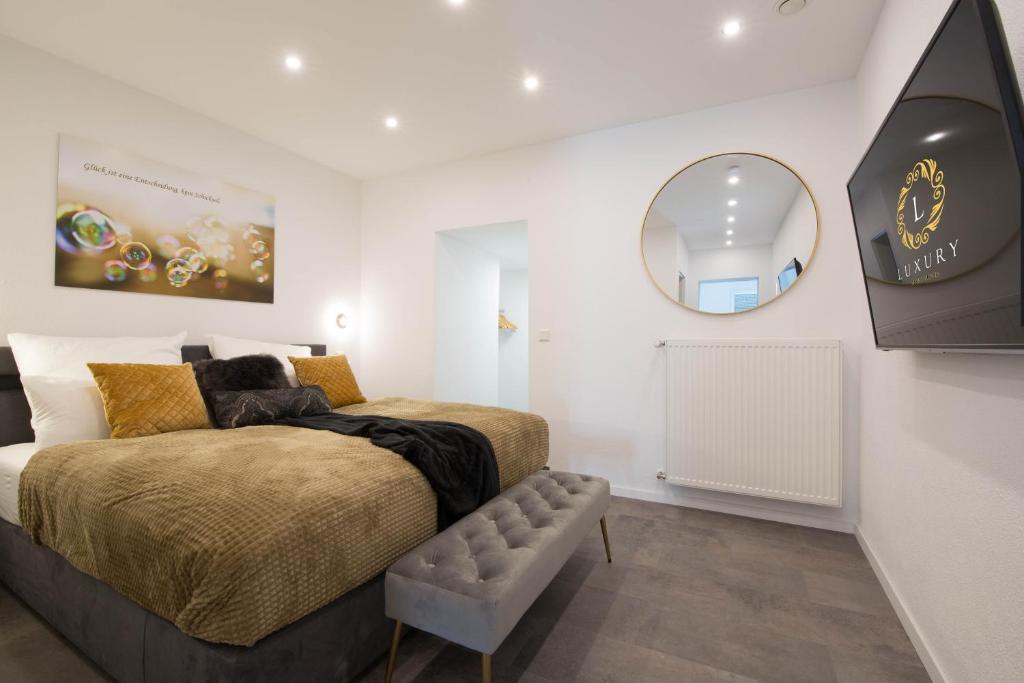 a bedroom with a bed and a round mirror at Luxury Saarbrücken 1 in Saarbrücken