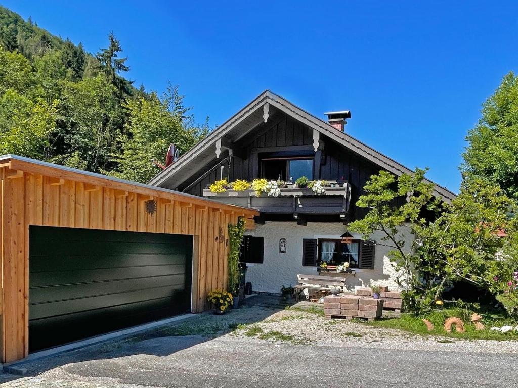 une maison avec une porte de garage et un bâtiment dans l'établissement Ferienwohnung am Kieferbach, à Kiefersfelden