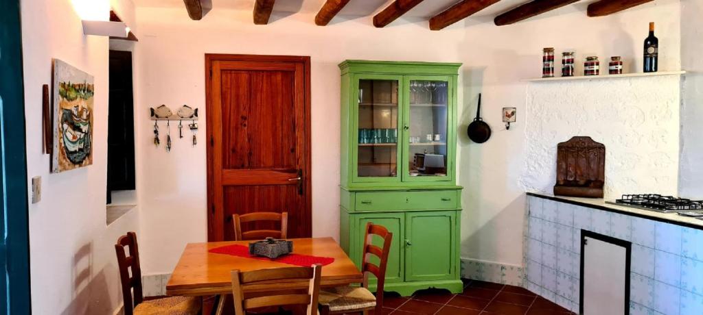 eine Küche mit einem Tisch und einem grünen Schrank in der Unterkunft Villa Chiara in Filicudi
