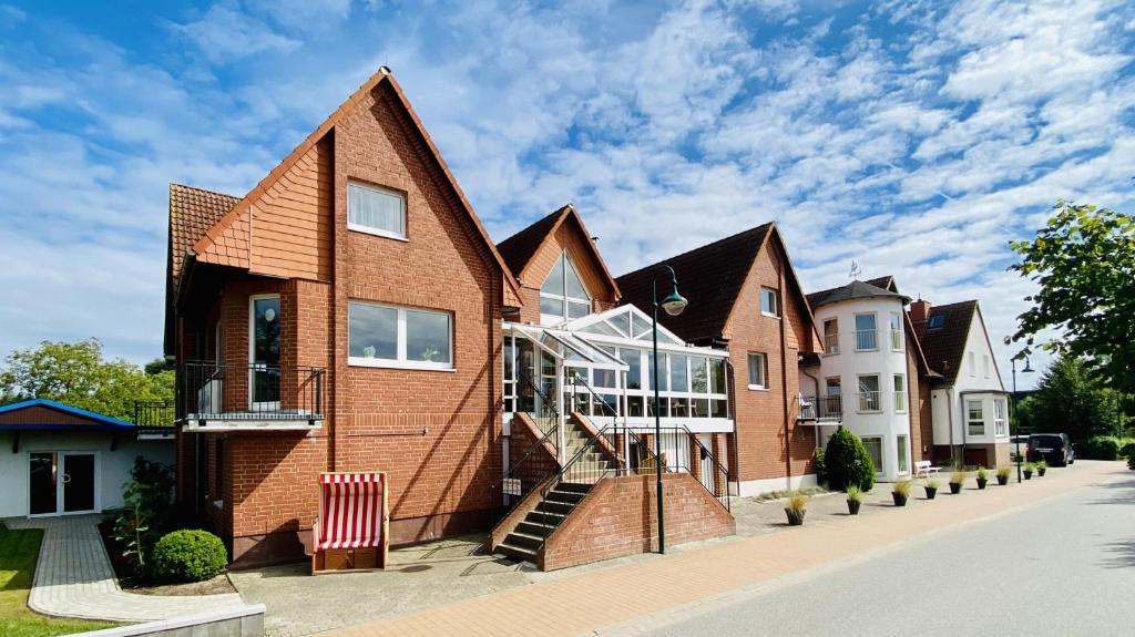 une maison en briques avec un escalier dans une rue dans l'établissement Pension Kühne, à Boltenhagen