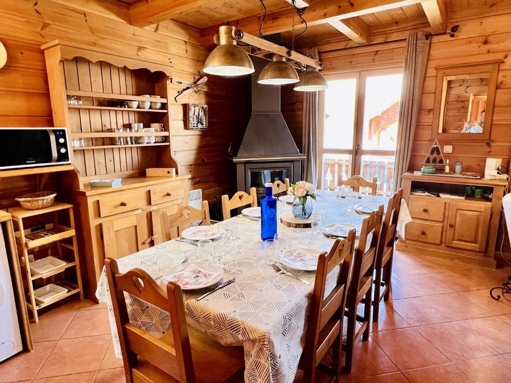 uma sala de jantar com uma mesa e cadeiras numa cozinha em Chalet de 3 chambres avec piscine partagee sauna et terrasse a Le Devoluy em Le Dévoluy