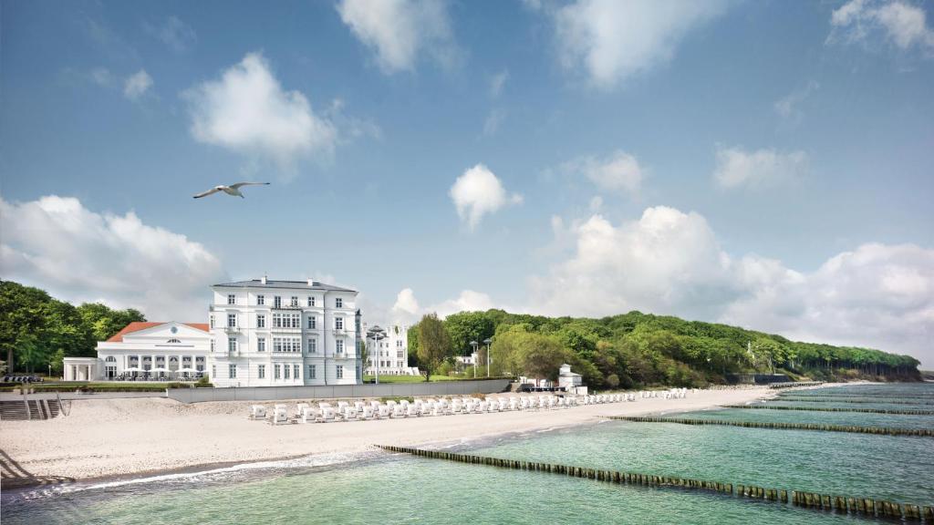 a beach scene with a couple of boats in the distance at Grand Hotel Heiligendamm - The Leading Hotels of the World in Heiligendamm