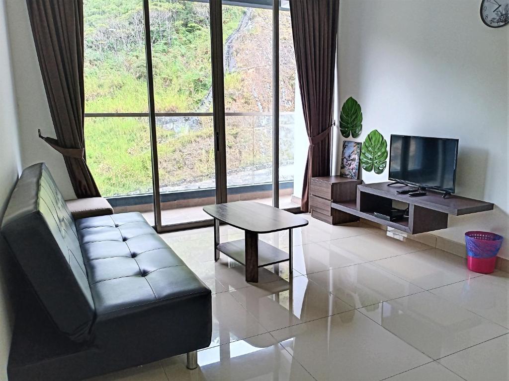 a living room with a couch and a table and a tv at Cozy Homestay at Palas Horizon @ Kea Farm/6 pax in Brinchang