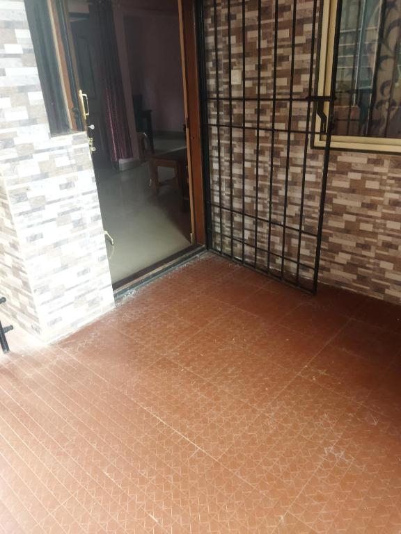 an empty room with a door and a tile floor at Hidden gem home stay -2 in Madikeri
