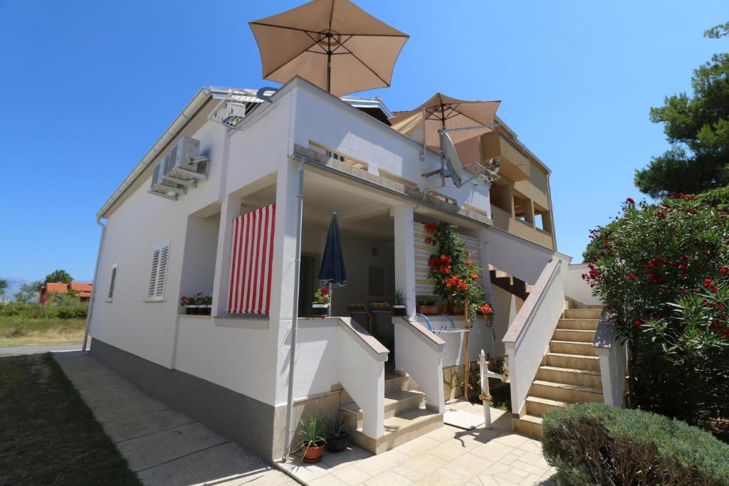 uma casa branca com escadas e flores em Apartments with a parking space Nin, Zadar - 11402 em Nin
