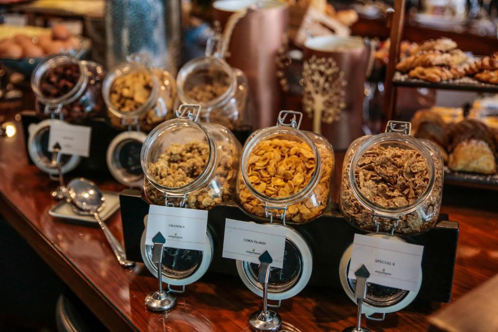 a buffet of food in glass dishes on a table at InterContinental Cascais-Estoril by IHG in Estoril