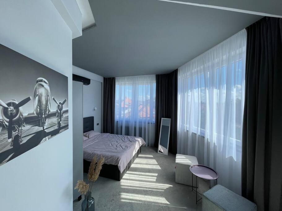 a bedroom with a bed and a large window at Engels apartments - studio luminos in Cluj-Napoca