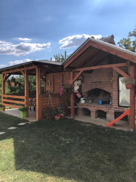 a pavilion with a fireplace in a yard at Kuca za odmor Davidovic in Despotovac