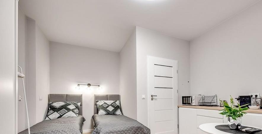 a white room with two beds and a kitchen at Central Platinum Apartments 25 in Rybnik