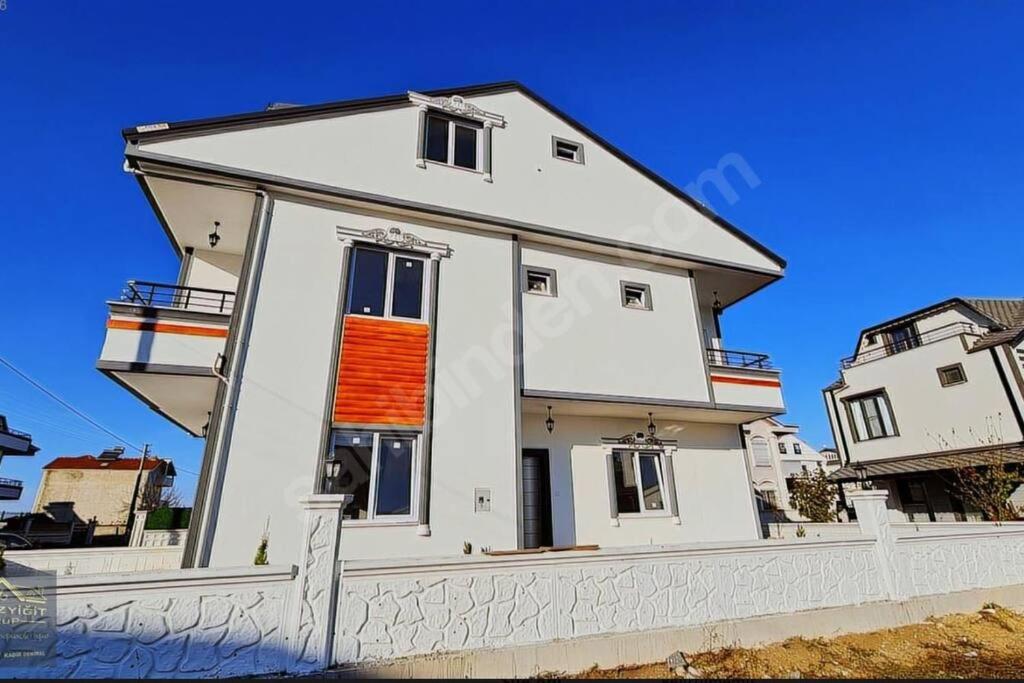 Una gran casa blanca con una ventana naranja. en Cheerful villa in Kocaali 80 m from sea en Yukarı Kocaali