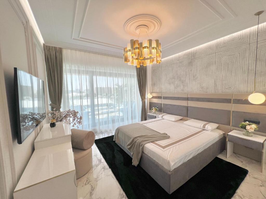 Un dormitorio con una cama y una lámpara de araña. en FIRST RESIDENCe, en Mamaia