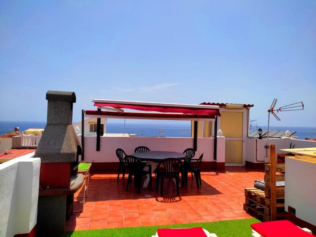 eine Terrasse mit einem Tisch, Stühlen und Meerblick in der Unterkunft Sea view apartment in Alcalá in Alcalá