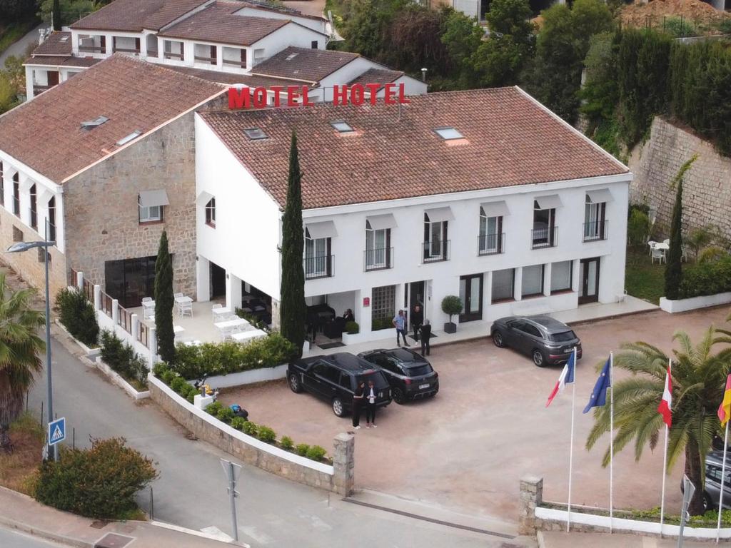 een luchtzicht op een huis met auto's geparkeerd op een parkeerplaats bij Hôtel De Porticcio in Porticcio