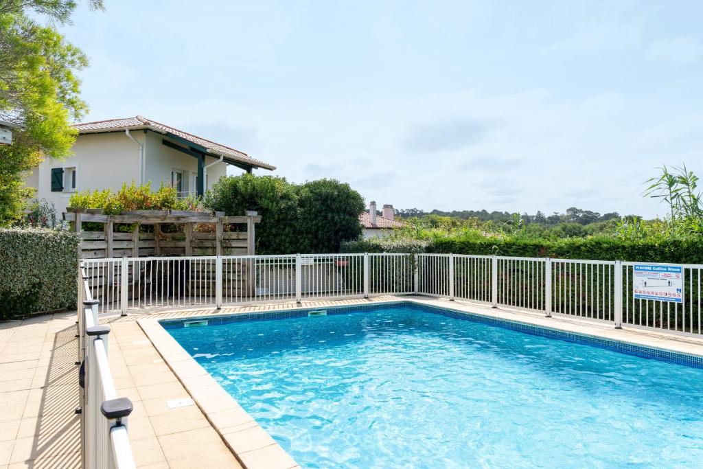 a swimming pool with a fence around it at Appartement La Coline Bleue in Biarritz