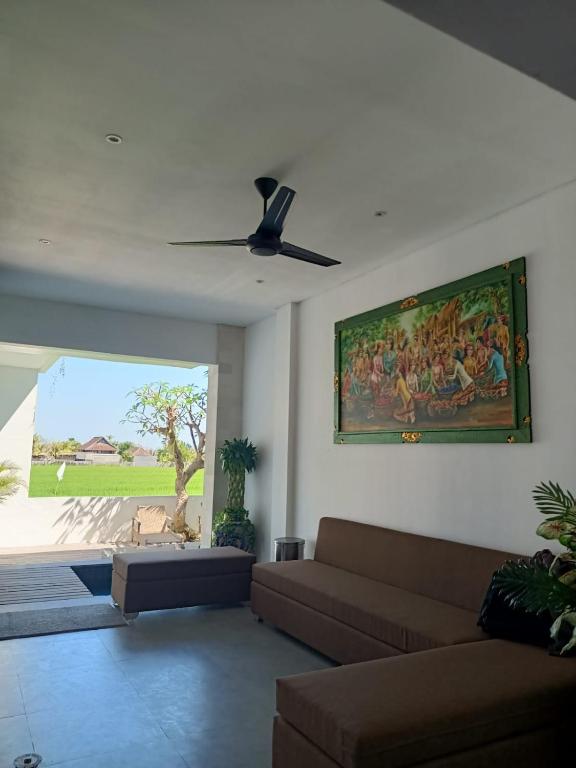 a living room with a couch and a painting on the wall at The Kd Suites & Coffee Shop in Munggu