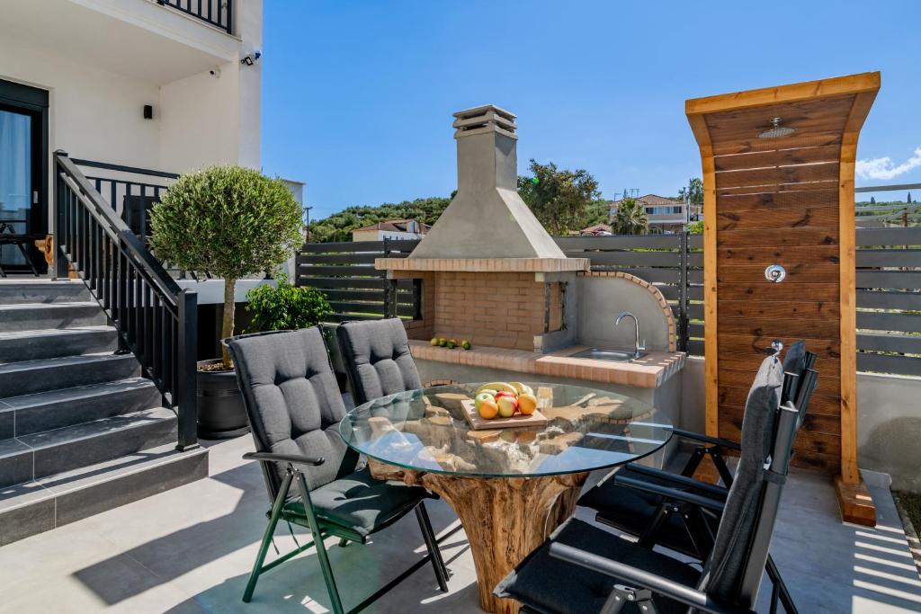 a patio with a table and chairs and a fireplace at Eagle's Nest - Adjoining Villas! in Tsilivi