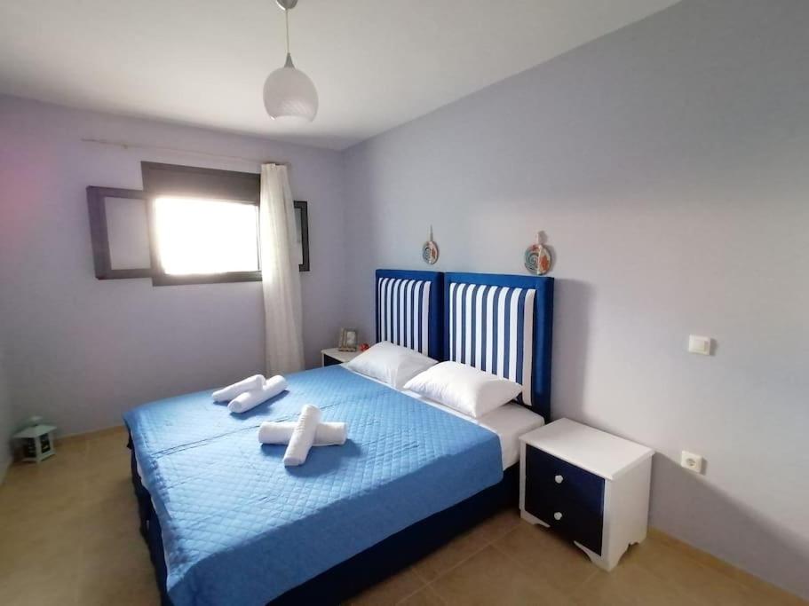 um quarto com uma cama azul com toalhas em Villa ioli at the sea breathtaking view & sunset em Ayios Nikitas