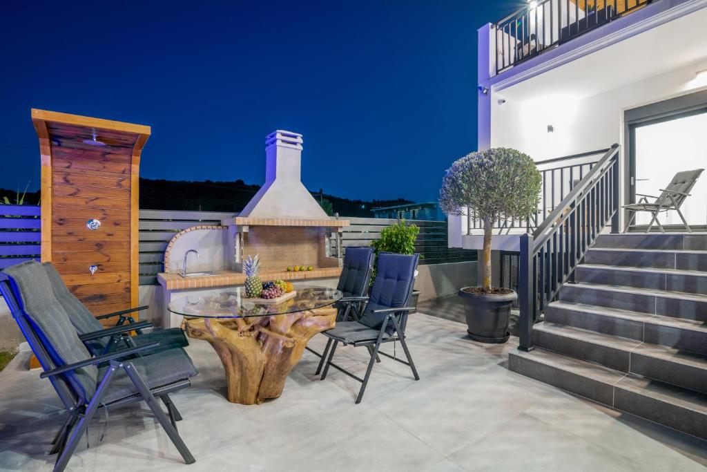 a patio with chairs and a table and a fireplace at Eagle's Nest - Adjoining Villas! in Tsilivi