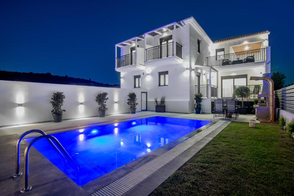 a villa with a swimming pool in front of a house at Eagle's Nest - Adjoining Villas! in Tsilivi
