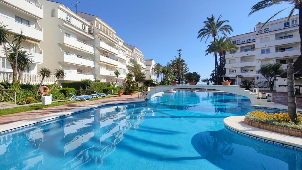 una grande piscina di fronte a un edificio di Estrelicia III a Marbella