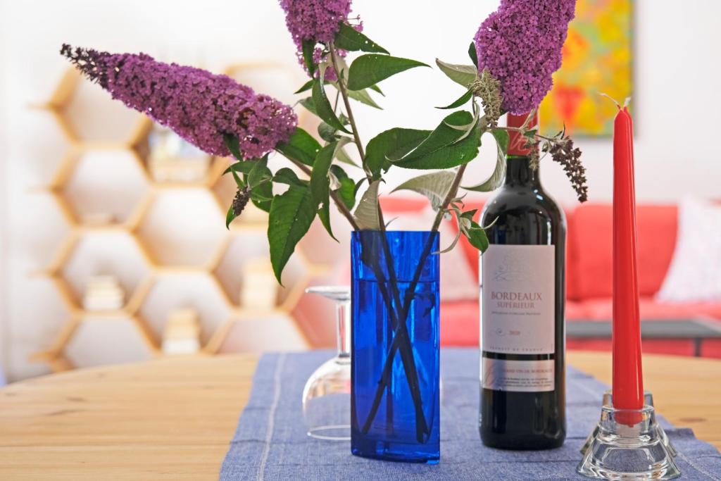 a table with a bottle of wine and purple flowers at Lescoat-le petit paradis in Plestin-les-Grèves