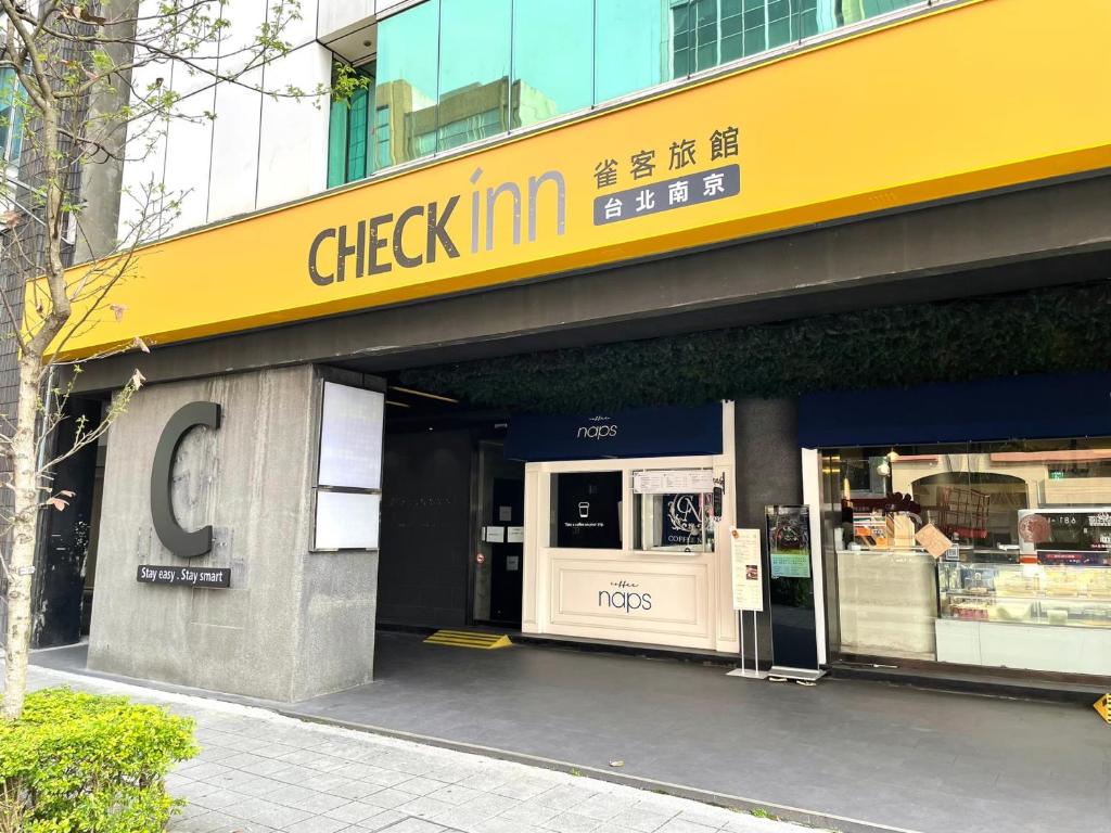 a grocery store with a yellow sign on a building at CHECK inn Taipei Nanjing in Taipei