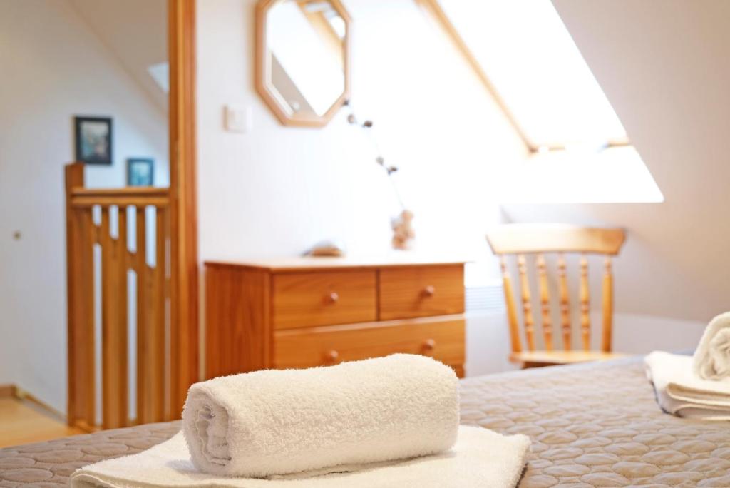 a pair of towels on a bed in a room at Lescoat-le petit paradis in Plestin-les-Grèves