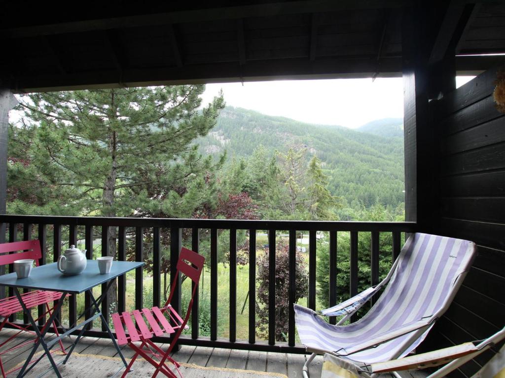 a patio with two chairs and a table on a balcony at Appartement Saint-Chaffrey , 3 pièces, 6 personnes - FR-1-330E-106 in Saint-Chaffrey