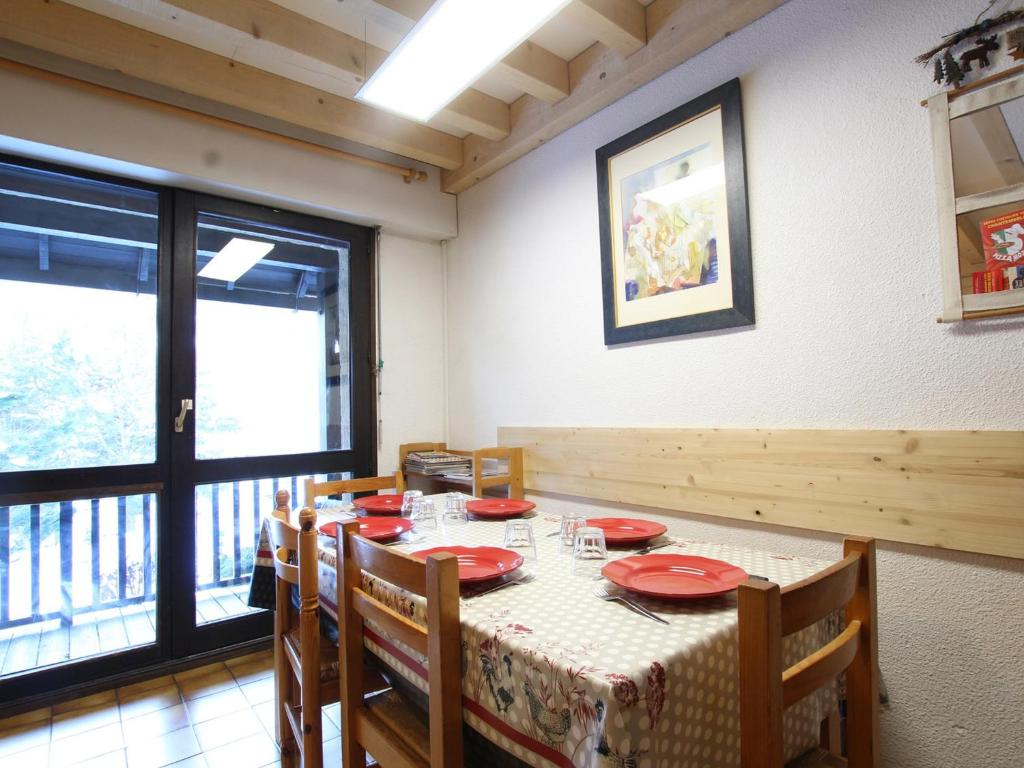 a dining room with a table with red plates at Appartement Saint-Chaffrey , 3 pièces, 6 personnes - FR-1-330E-106 in Saint-Chaffrey