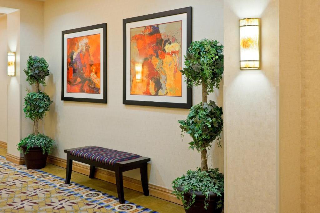 a waiting room with a bench and paintings on the wall at Holiday Inn South Plainfield-Piscataway, an IHG Hotel in South Plainfield