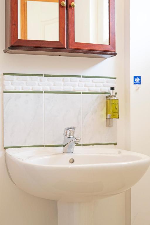 a white sink in a bathroom with a mirror at Lescoat-le petit paradis in Plestin-les-Grèves