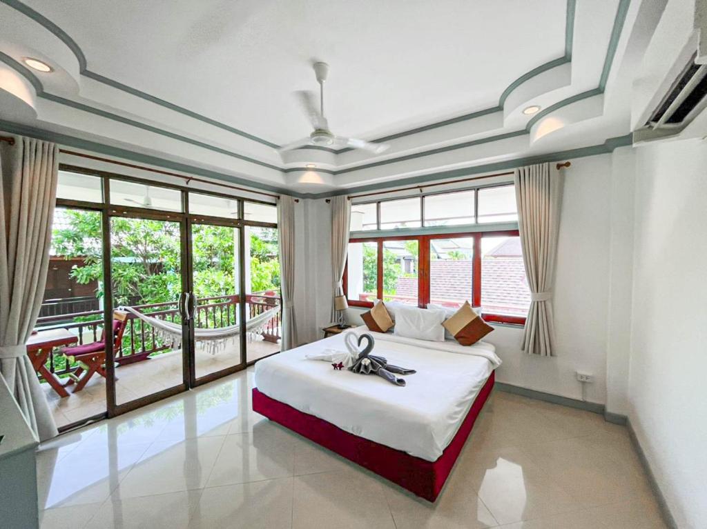 a bedroom with a bed and a large window at TropiCoco Beach Resort Koh Phangan in Haad Yao