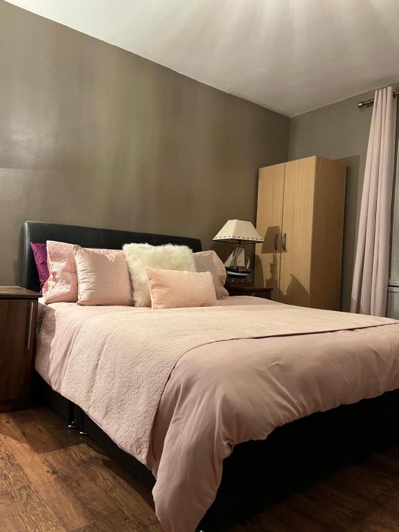 a bedroom with a large bed with pink pillows at Medway Stay in Chatham