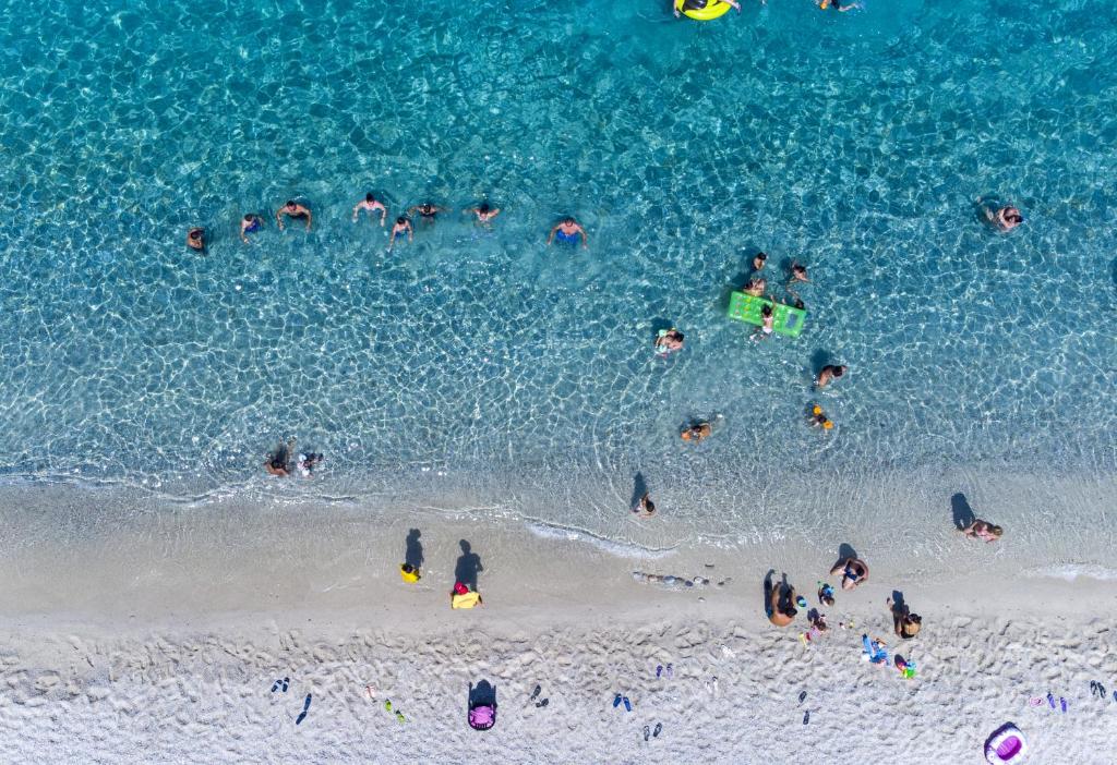 a group of people in the water at the beach at Il Calabriano Residence in Zambrone