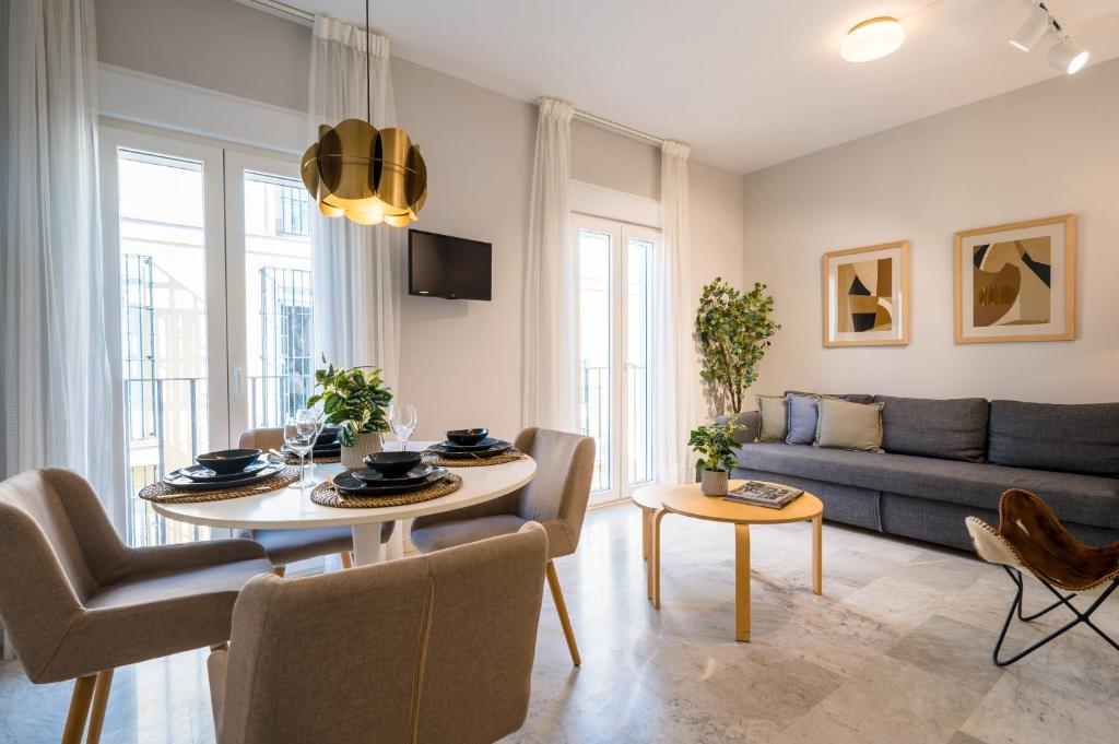 ein Wohnzimmer mit einem Sofa und einem Tisch in der Unterkunft Magno Apartments Guadalquivir Terrace in Sevilla