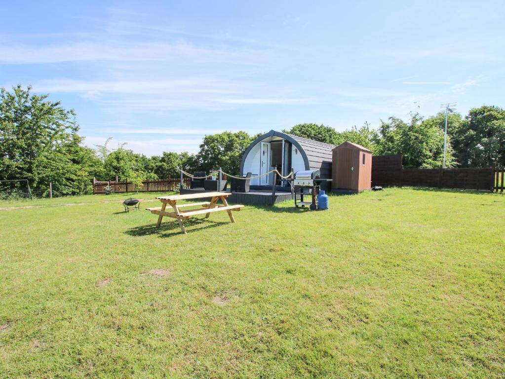 a picnic table and a tent in a field at Cherry Pod in Shrewsbury