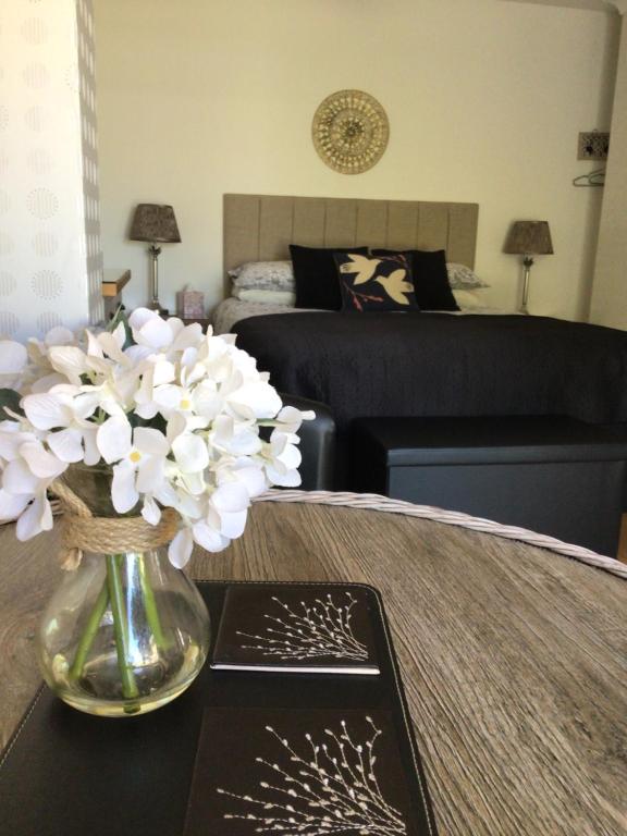 a vase of flowers on a table in a living room at Forest B & B in Ringwood