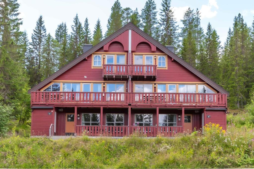 ein rotes Haus mit einer Terrasse auf einem Hügel in der Unterkunft Bakkebyvegen 1D in Trysil