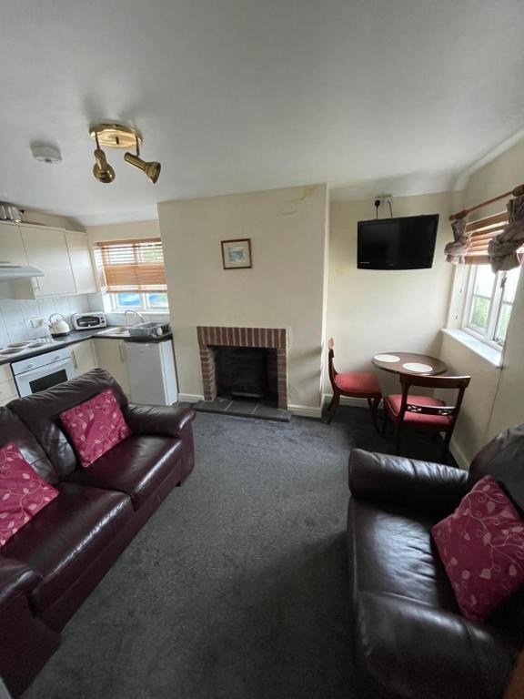 a living room with a couch and a fireplace at Halfway House Inn & Cottages in Bridgnorth