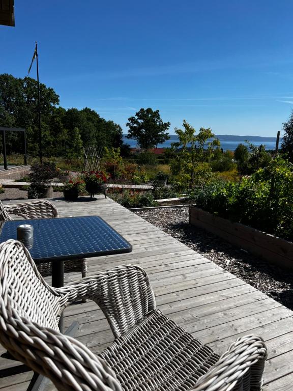 una mesa de picnic y 2 sillas en una terraza de madera en Fantastisk Vätterutsikt mellan Habo och Bankeryd. en Habo