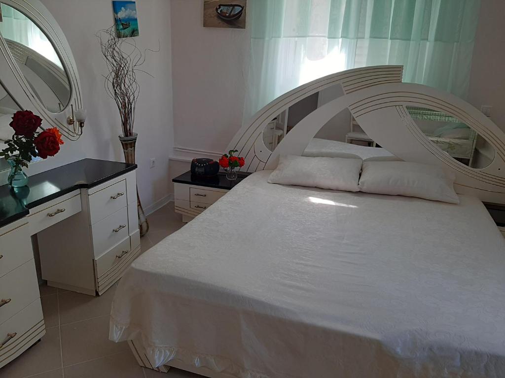 ein Schlafzimmer mit einem großen weißen Bett und einem Spiegel in der Unterkunft Cozy flat in Nea Makri in Nea Makri