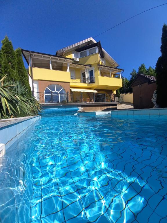una casa con piscina frente a una casa en Villa Ajka, en Sarajevo