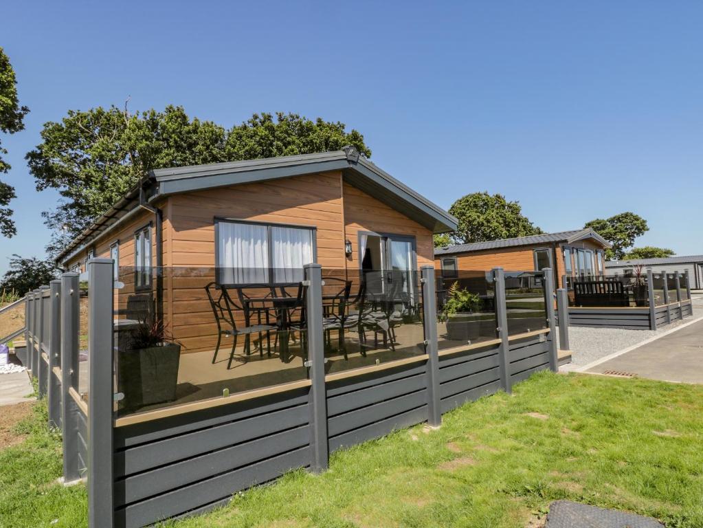 a cabin with a deck with a table and chairs at Brighter Daze in Bridlington