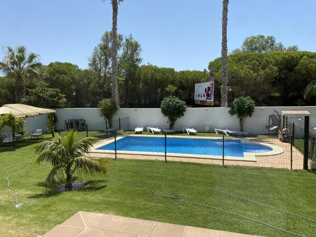 a fence around a swimming pool in a yard at Villa Loma Beach in Chiclana de la Frontera