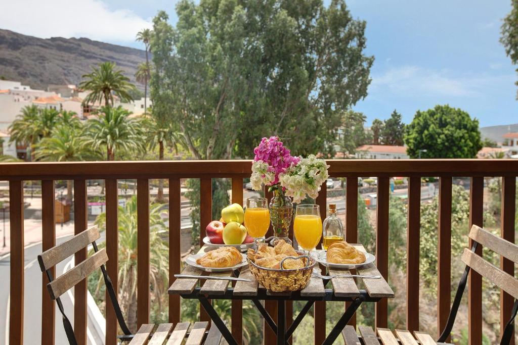 a table with food and fruit on a balcony at Holiday Cottage Santa Lucía 1 in Santa Lucía