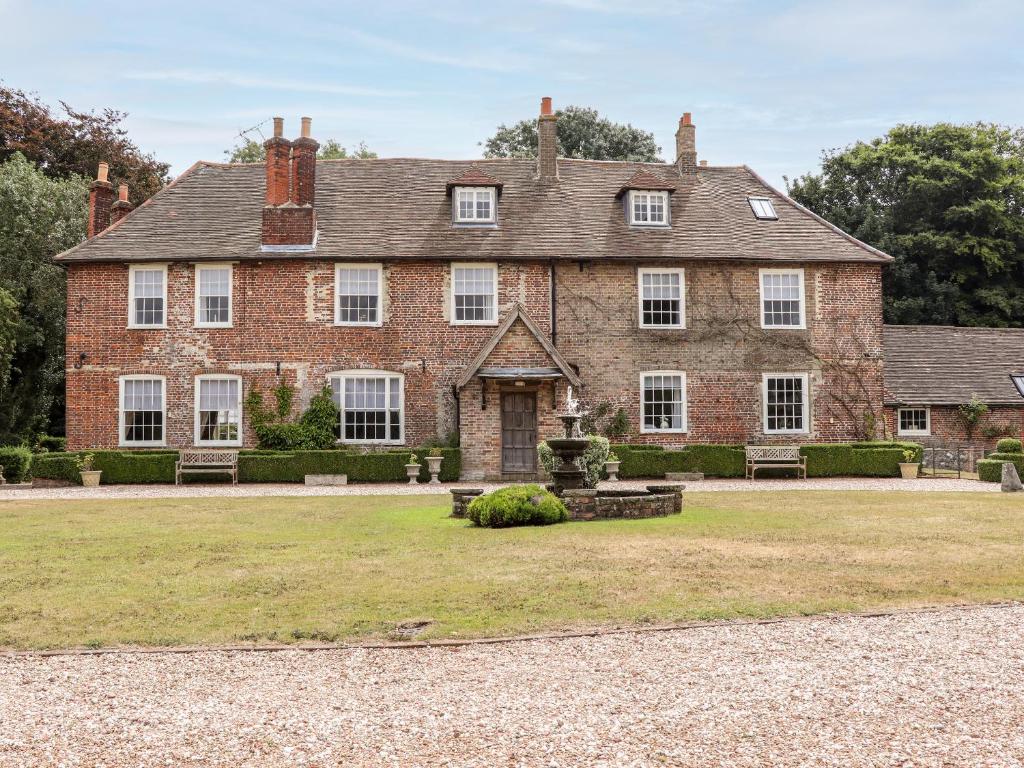 a large brick house with a yard in front of it at Solton Manor in Dover