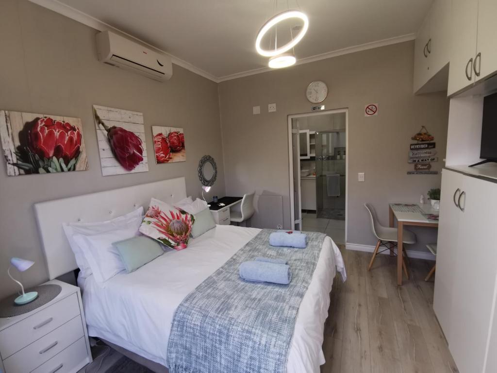a bedroom with a large bed and a kitchen at Protea Suite in Bellville